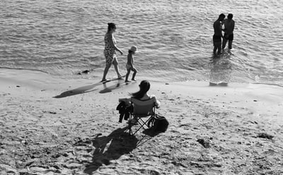 During the day, a man and a woman were sitting on the beach of folding chairs
